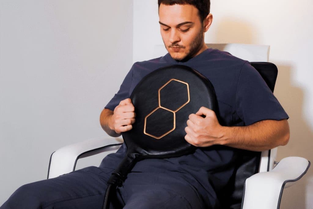A member holding the PEMF applicator during a session at Biowell Health in Battersea, London